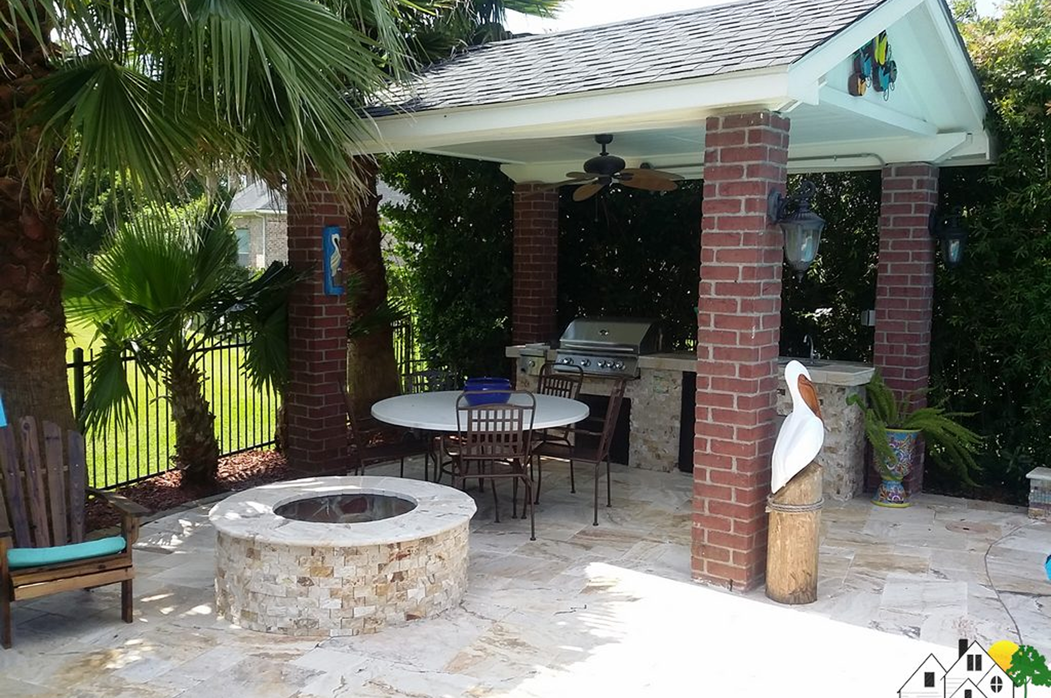 Cozy outdoor patio with brick pillars and a stone fire pit.