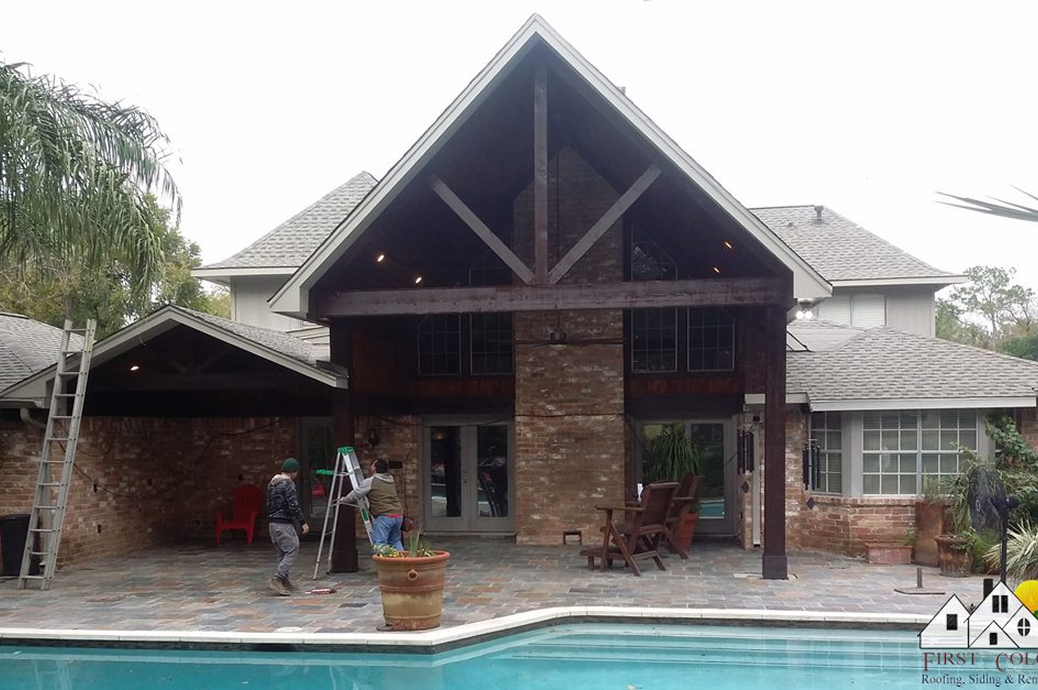 A cozy backyard patio with a pool and stone house exterior.