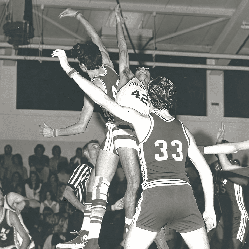 Basketball players jumping for the ball