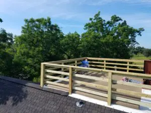 A wooden deck under construction with a person working on it.