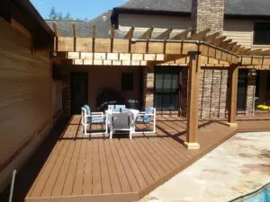 Cozy outdoor patio with wooden pergola and seating area.