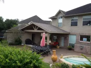 Cozy backyard patio with seating, umbrella, and small pool.