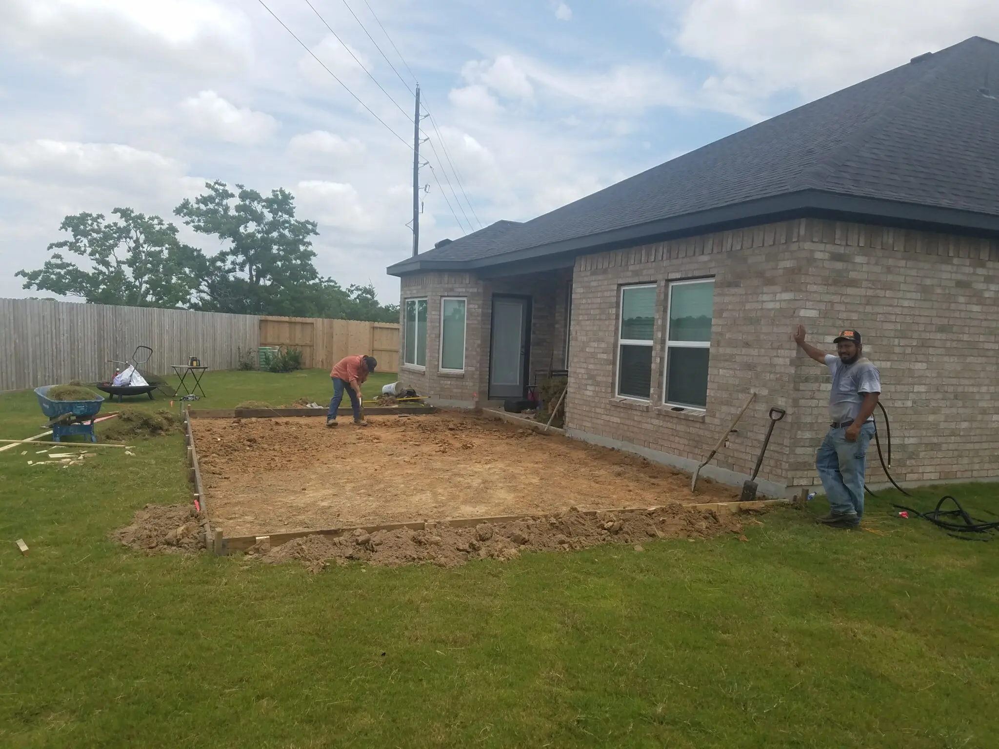Backyard construction site preparing for a patio or foundation next to a house.