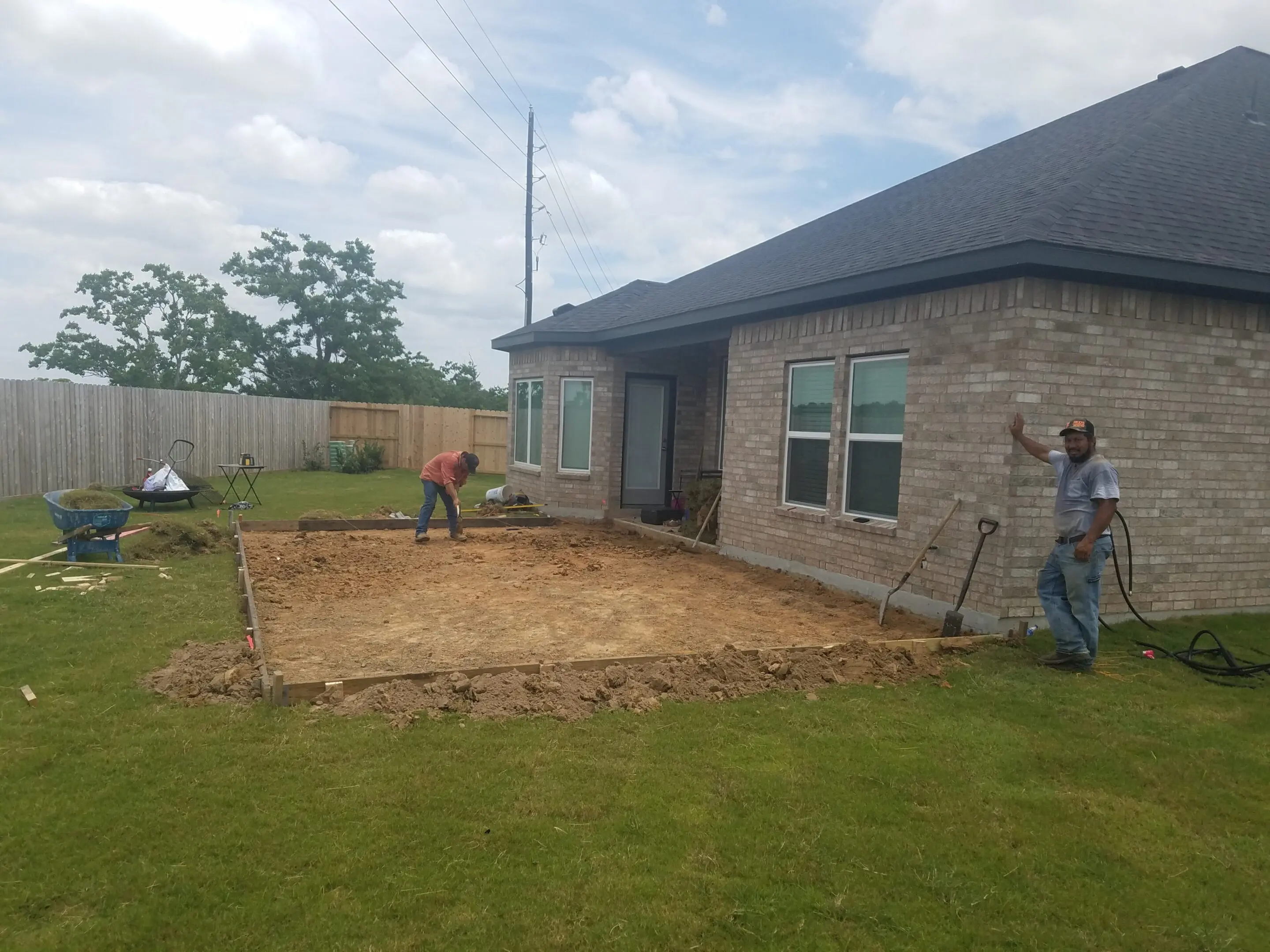 Backyard construction site preparing for a patio or foundation next to a house.