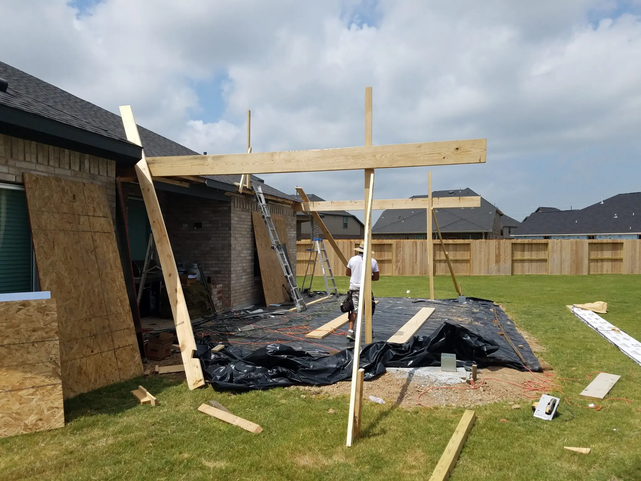 Wooden frame structure under construction in a backyard.