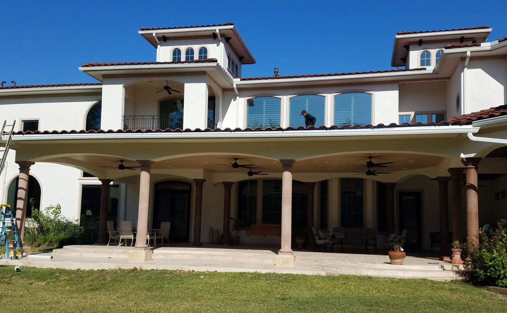 Large modern house with two towers under a clear blue sky.