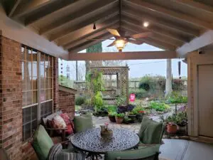 Cozy covered patio with garden views and comfortable seating.
