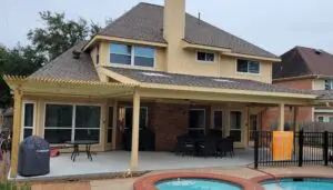 A suburban house with a covered patio and a small round pool.
