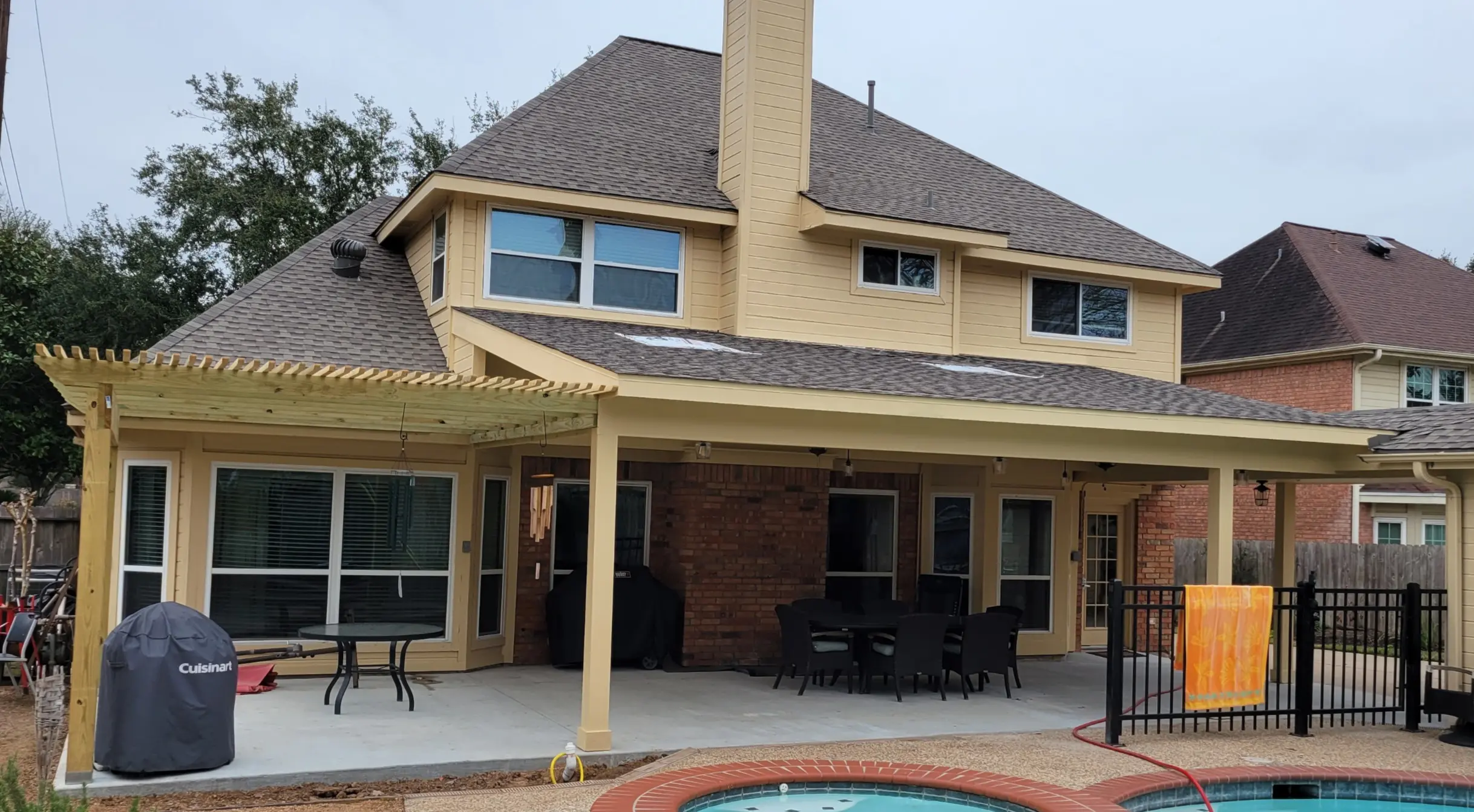 Large two-story house with a covered patio and swimming pool.