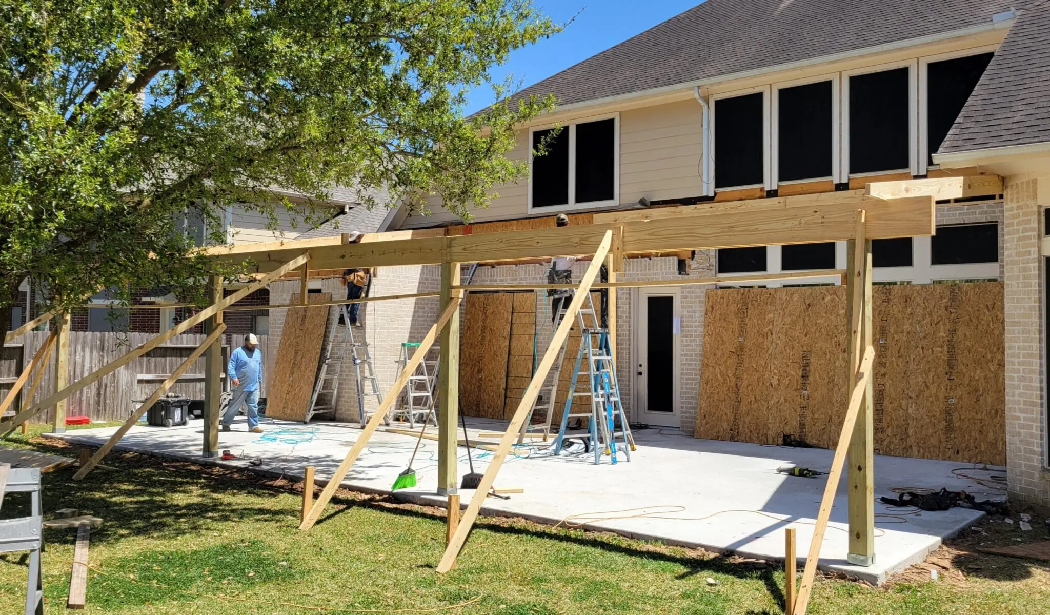 Construction workers framing a building's exterior with wooden beams.