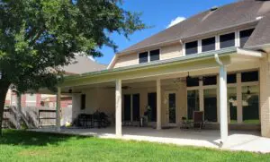 Spacious backyard patio with seating and ceiling fans under a covered porch.
