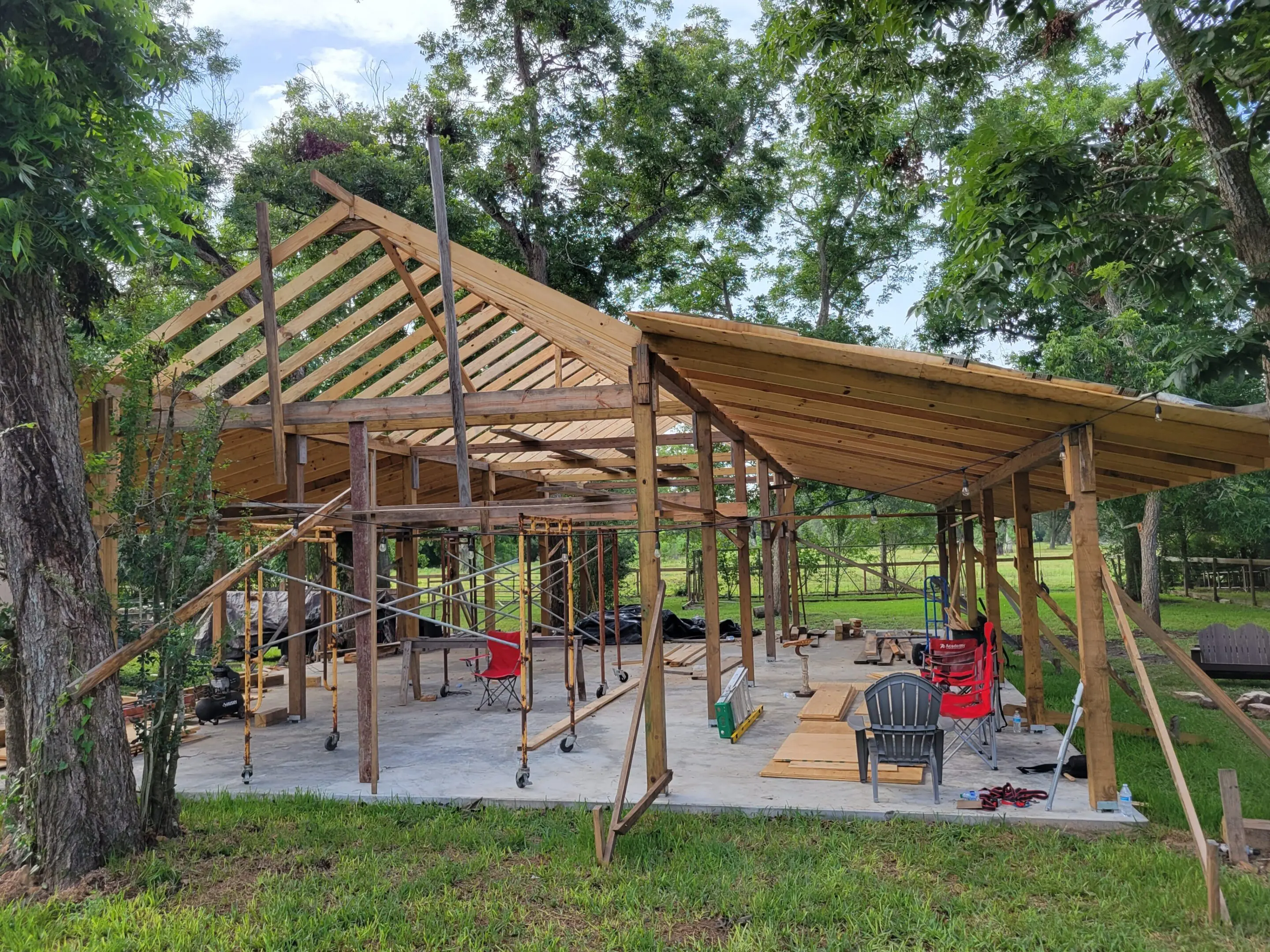 Partially constructed wooden structure in a green outdoor area.