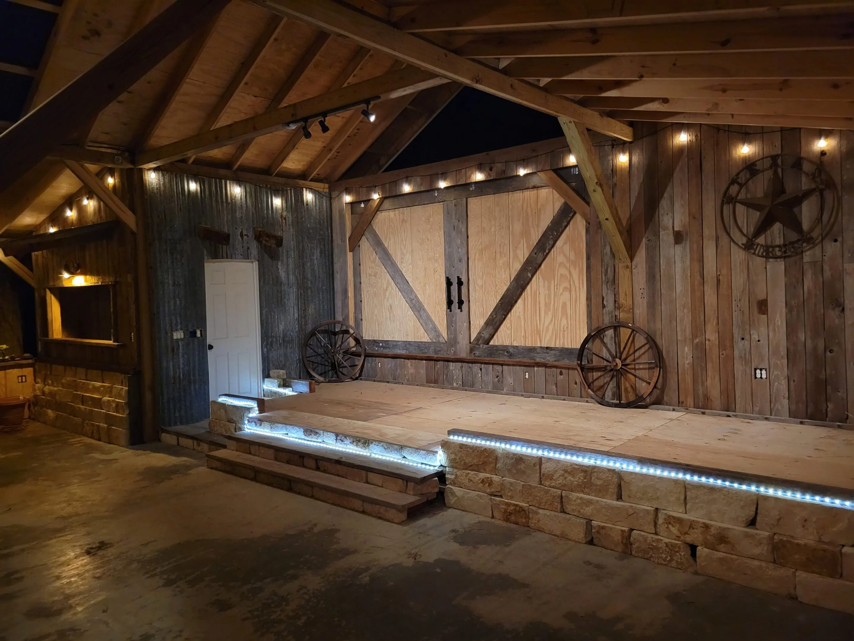 Rustic wooden interior with a raised platform and string lights.