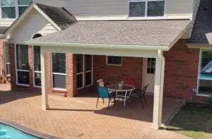 Cozy outdoor patio with a table and chairs under a covered roof.