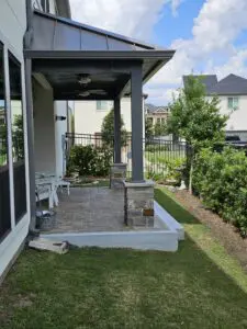 Cozy backyard porch with stone pillars and garden seating area.