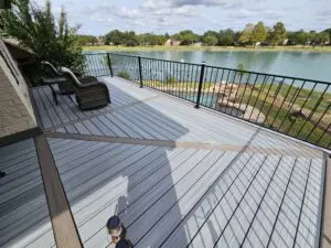 A serene lakeside deck with seating and a safety railing.