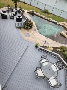 Modern backyard deck with seating and a stone-bordered pond.