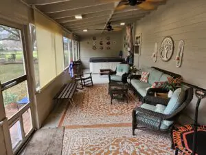 Cozy sunroom with wicker furniture and patterned rug.