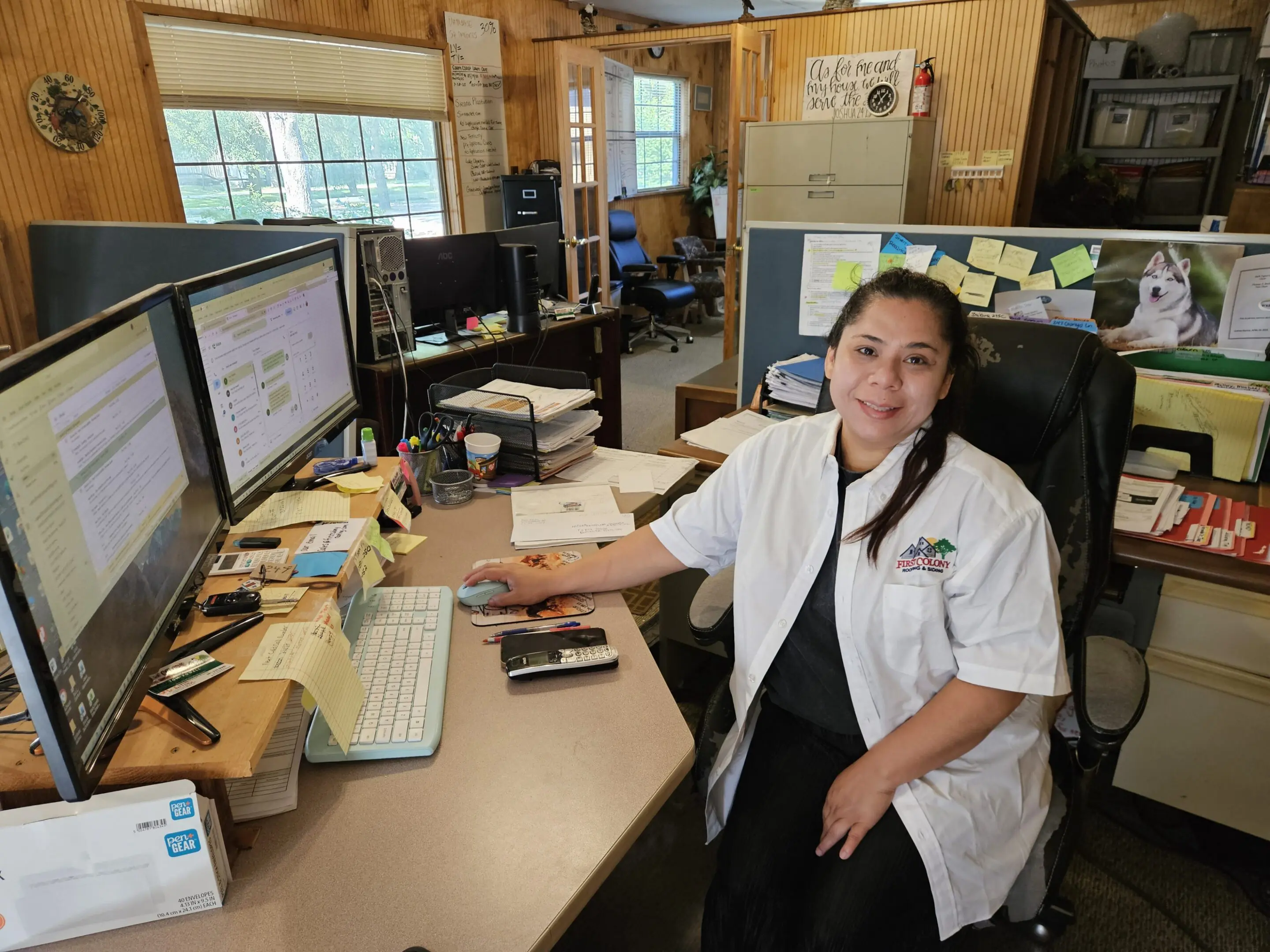 Woman in lab coat at desk with monitors