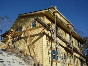 Yellow house with scaffolding and ladder