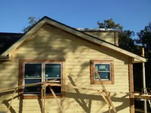 Yellow house gable with scaffolding and windows