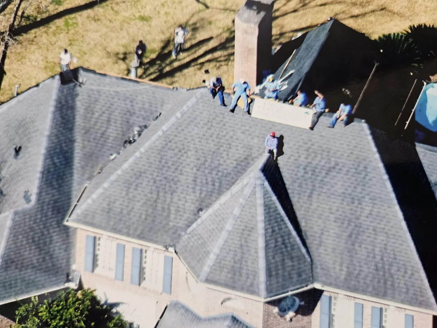 Aerial view of workers installing roof shingles