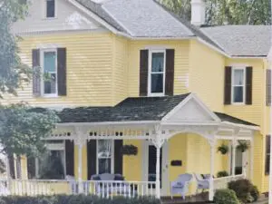 Yellow Victorian house with white wraparound porch