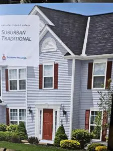 Gray suburban house with red door and shutters
