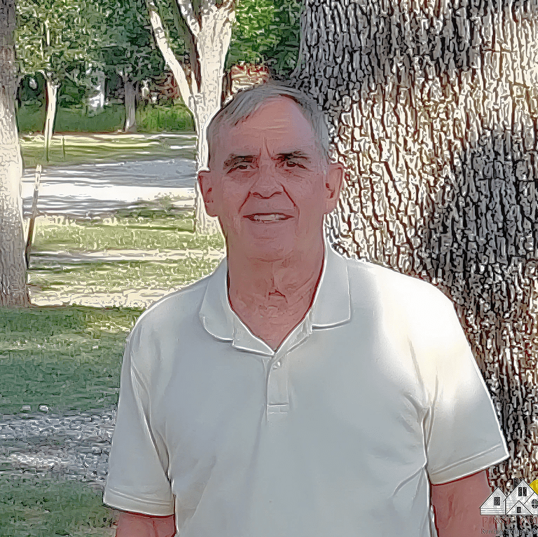 An elderly man in a white polo shirt stands outdoors near a tree.